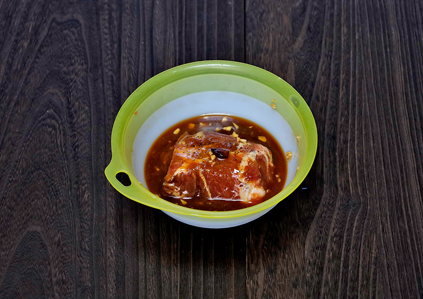 豚肩ロース肉をたれに漬け込む